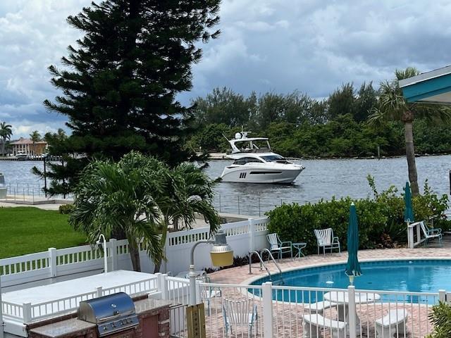 A white yacht cruises on a waterway past a backyard with a pool and grill — 1201 N Riverside Drive # 12b, Pompano Beach FL 33062, POMPANO BEACH, FL