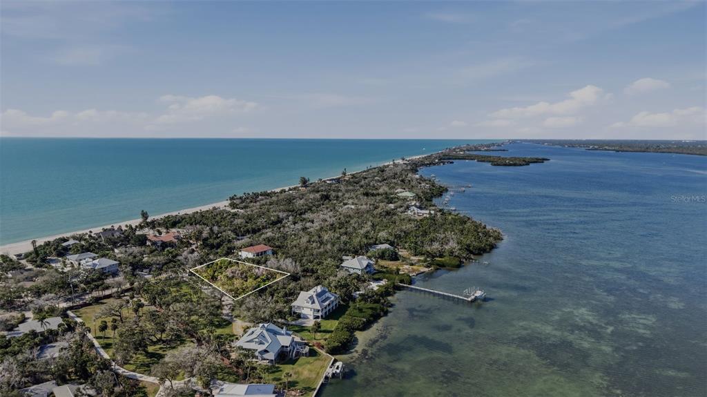 An aerial view shows a vacant, wooded lot outlined in white near a coastal shoreline — MANASOTA KEY ROAD, ENGLEWOOD, FL