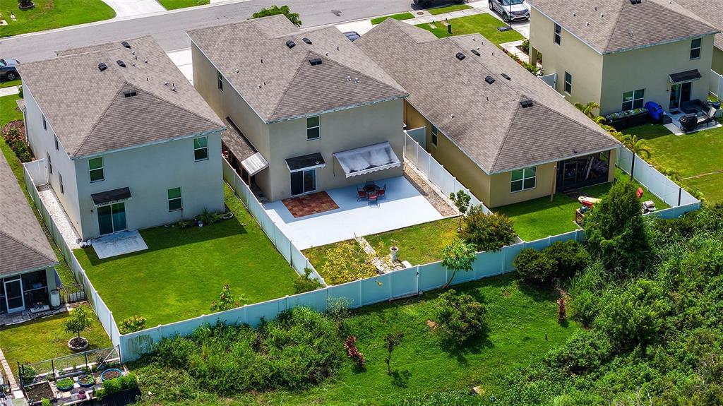 An aerial view shows three suburban houses with fenced backyards and green lawns — 5206 WILLOW BREEZE WAY, PALMETTO, FL