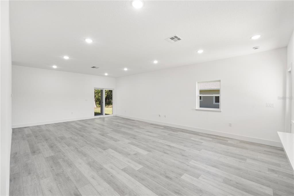 An empty room with white walls, recessed lighting, and light gray wood-look flooring — 820 E DESOTO STREET, CLERMONT, FL