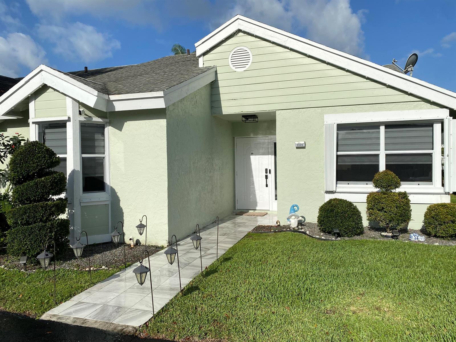 A light green house with a tiled walkway, white trim, and manicured shrubs — 1101 SW 111th Terrace, Davie FL 33324, DAVIE, FL