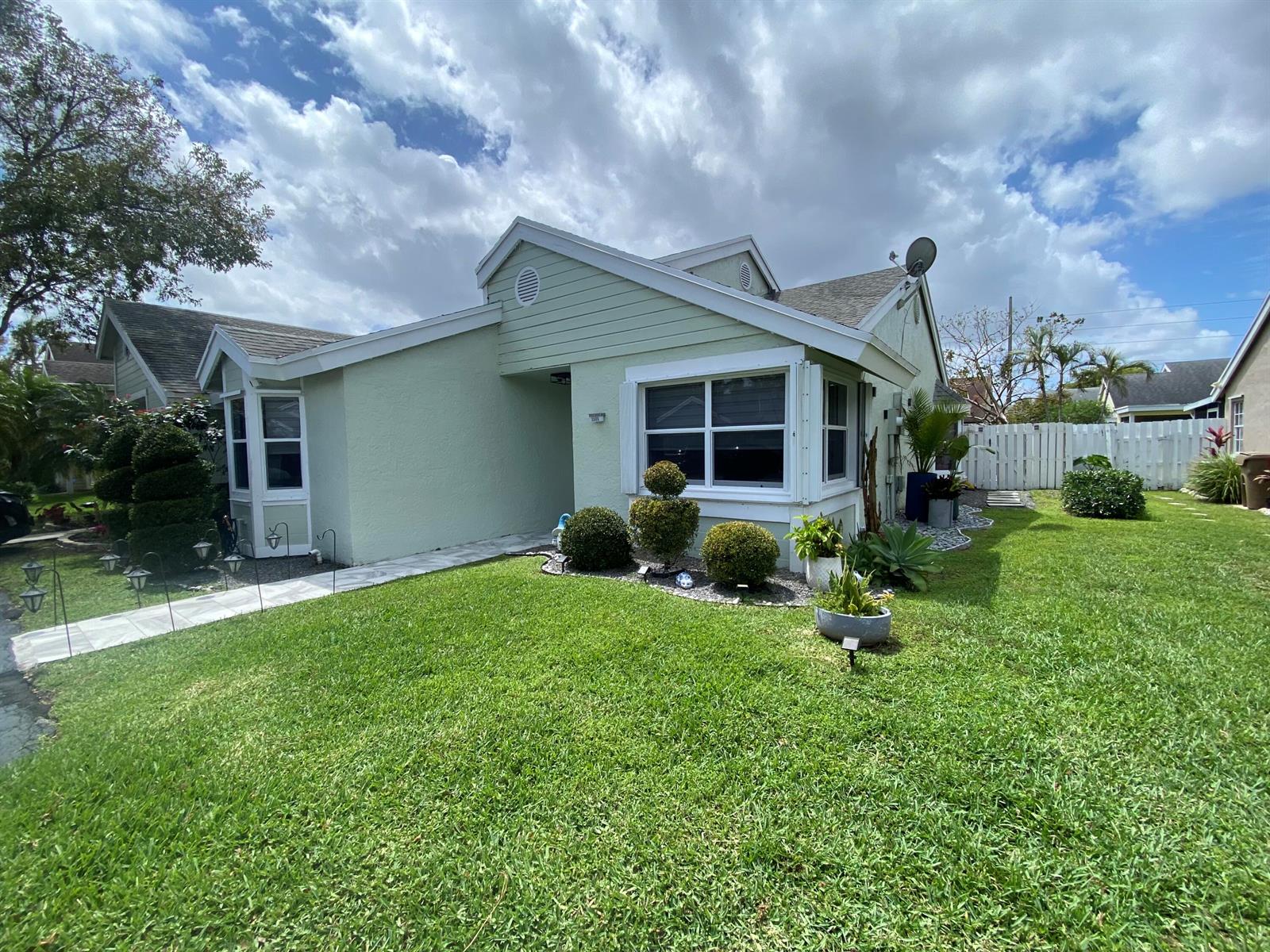 A light green single-story house with a white fence and a manicured lawn — 1101 SW 111th Terrace, Davie FL 33324, DAVIE, FL