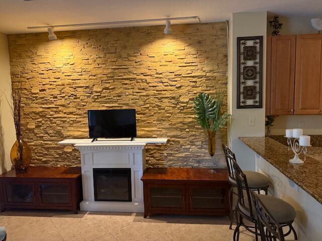 A living room features a stone accent wall, a white fireplace, and wood media consoles — 3171 SW Otter Lane, Stuart FL 34997, STUART, FL