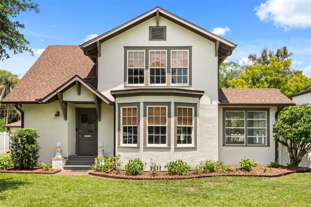 A two-story house with a white stucco exterior, brown trim, and a brown shingled roof — 2101 SANFORD AVENUE, SANFORD, FL