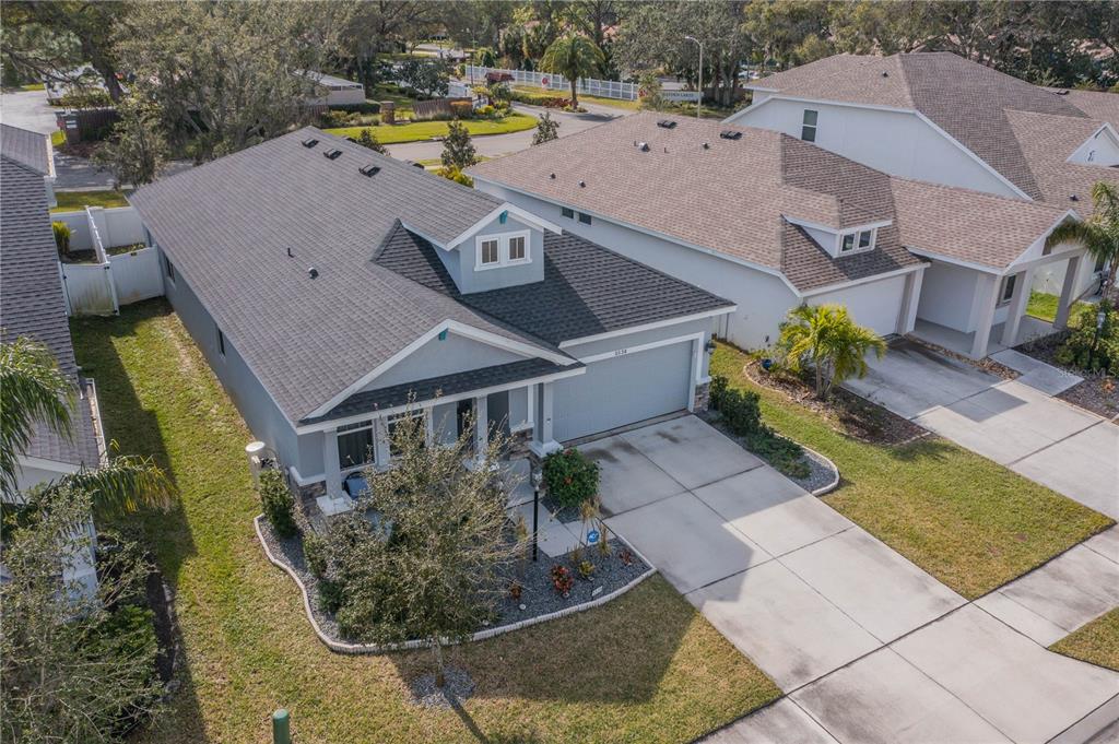 An aerial view shows a single-story house with a gray roof, garage, and landscaped yard — 5538 SPANISH MOSS COVE, BRADENTON, FL