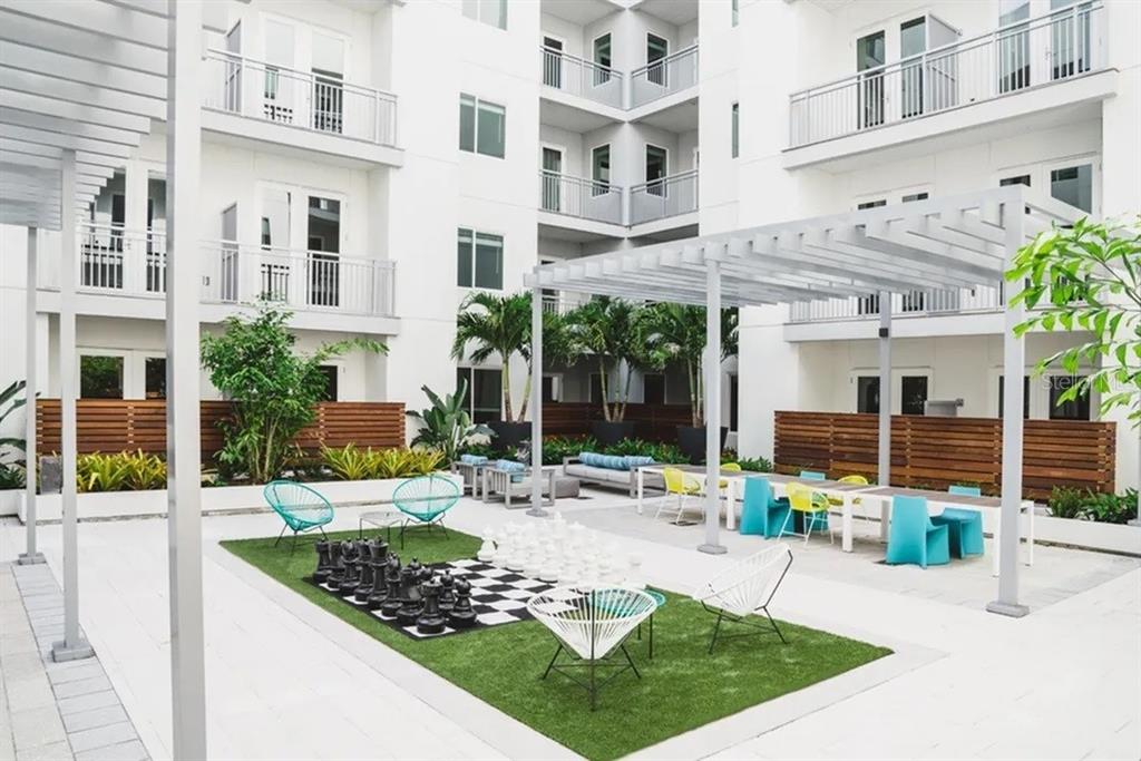 An outdoor courtyard featuring a giant chess set, patio furniture, and a pergola — 505 CHATHAM AVENUE, ORLANDO, FL