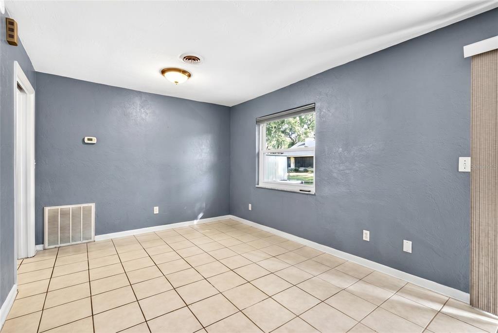 An empty room with blue walls, tile flooring, a ceiling light, and a window — 2622 SW 35TH AVENUE, OCALA, FL