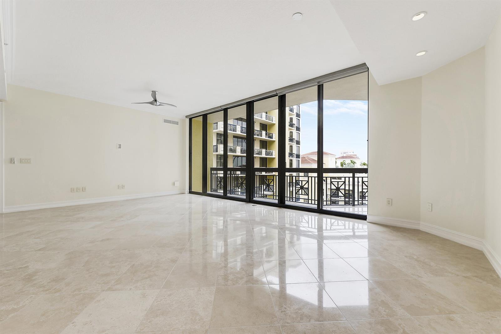 An empty living room with polished tile floors, a ceiling fan, and floor-to-ceiling windows — 701 S Olive Avenue # 1706, West Palm Beach FL 33401, WEST PALM BEACH, FL