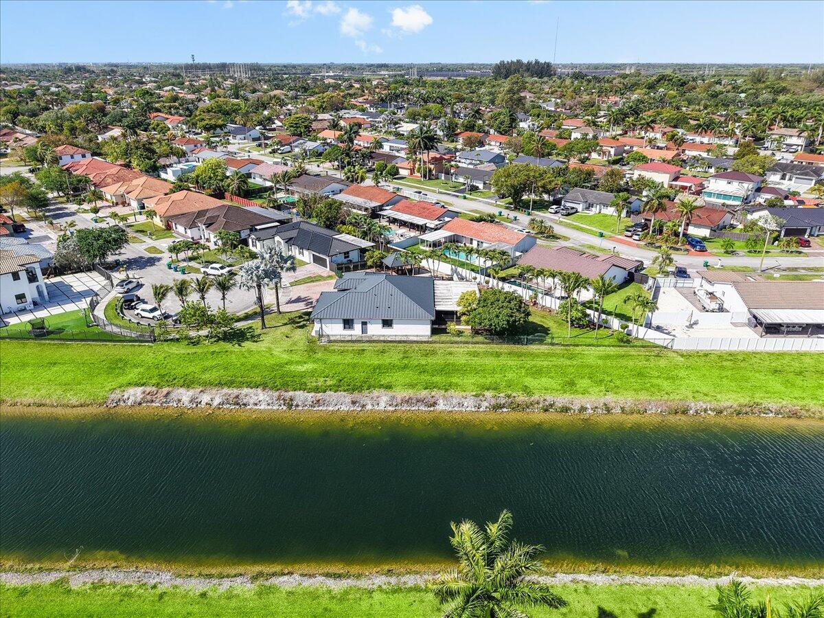 An aerial view of a suburban neighborhood featuring a canal and single-family homes — 20300 SW 129th Place, Miami FL 33177, MIAMI, FL