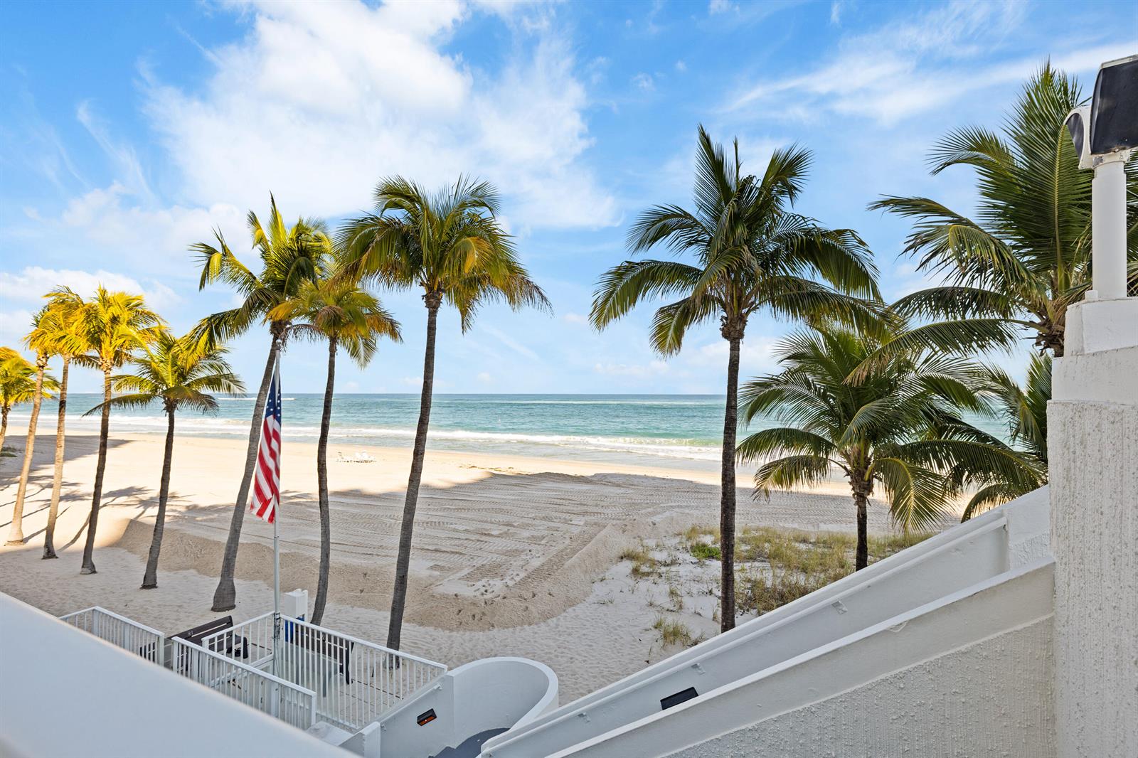 A view of a sandy beach and ocean from a balcony with palm trees — 1360 S Ocean Boulevard # 403, Pompano Beach FL 33062, POMPANO BEACH, FL