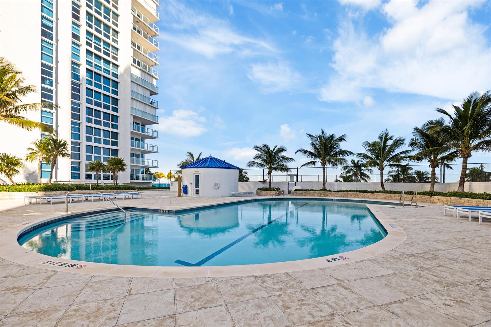 A swimming pool with a blue roofed cabana and a tall residential building nearby — 1360 S Ocean Boulevard # 403, Pompano Beach FL 33062, POMPANO BEACH, FL