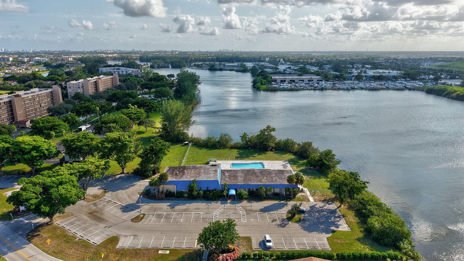 An aerial view shows a building with a blue roof, a pool, and a parking lot — 4821 NW 13th Avenue, Deerfield Beach FL 33064, DEERFIELD BEACH, FL