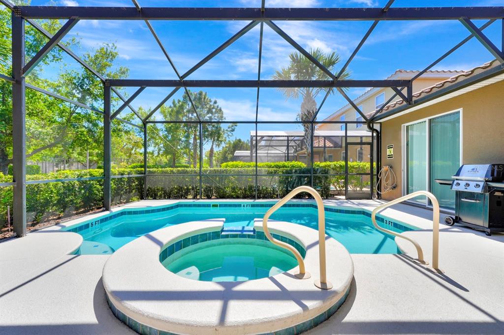 A screened-in patio features a swimming pool and a circular hot tub — 4416 ACORN COURT, DAVENPORT, FL