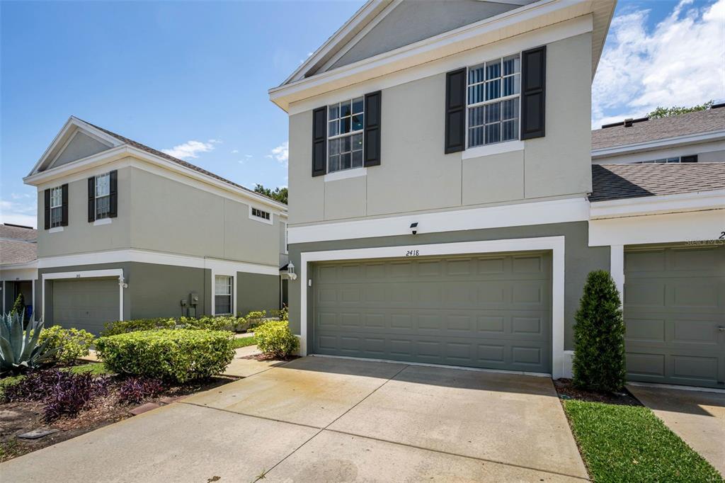 A two-story townhouse with a two-car garage and a concrete driveway — 2418 EARLSWOOD COURT, BRANDON, FL