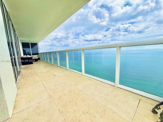 A spacious balcony with light tile flooring overlooks the ocean behind a glass railing — 1830 S Ocean Dr # 3702, Hallandale Beach FL 33009, HALLANDALE BEACH, FL