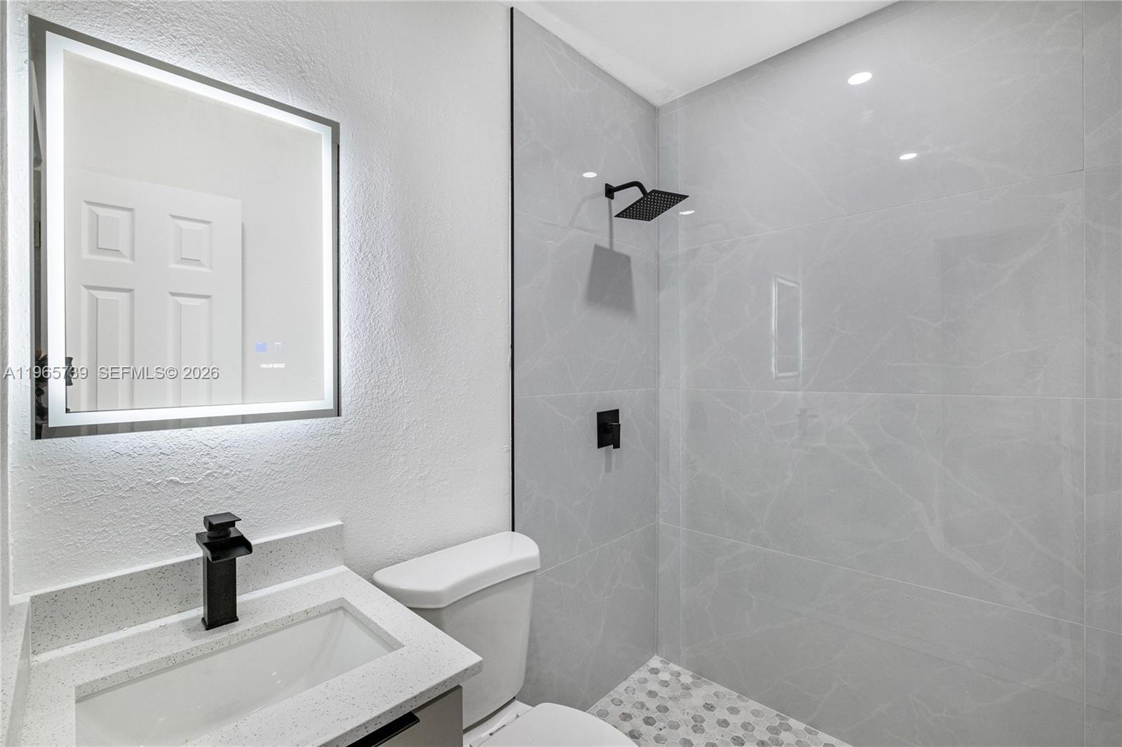 A modern bathroom features a vanity with a black faucet, a toilet, and a tiled shower — 6905 NW 4th Ct # B, Miami FL 33150, MIAMI, FL