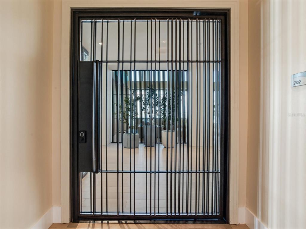 A black metal security gate with vertical bars stands in a doorway — 1209 E CUMBERLAND AVENUE UNIT 2902, TAMPA, FL