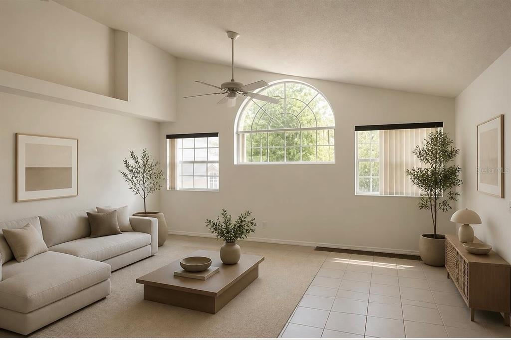 A living room with a vaulted ceiling, beige carpet, tile flooring, and a large arched window — 2000 ROYAL BAY BOULEVARD UNIT 132, KISSIMMEE, FL