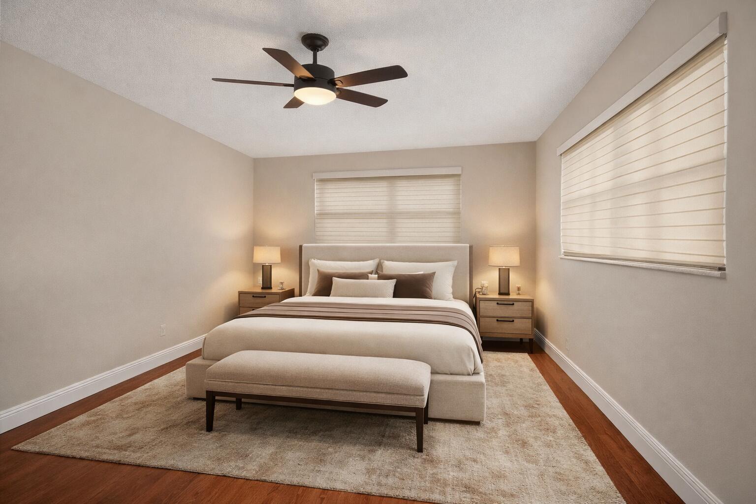 A bedroom features a bed with a bench, two nightstands, and a ceiling fan — 801 Meadowlark Lane, Delray Beach FL 33445, DELRAY BEACH, FL
