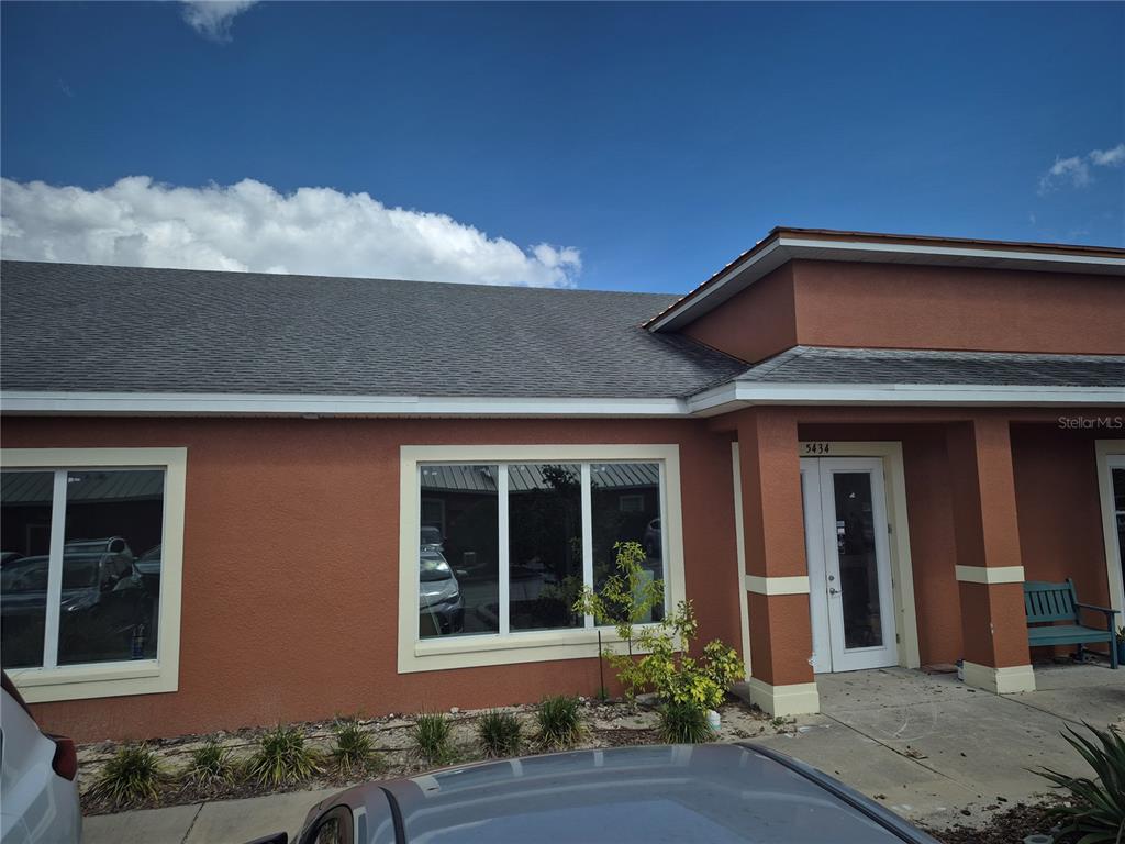 The exterior of a single-story commercial building with stucco walls and a shingled roof — 5434 LAND O LAKES BOULEVARD, LAND O LAKES, FL