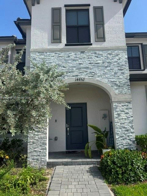 The exterior of a two-story house features a stone-veneer facade and a covered entryway — 14852 SW 183rd Ter, Miami FL 33187, MIAMI, FL
