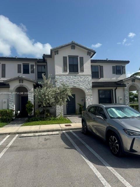 A two-story townhouse with a stone facade and a silver car parked in front — 14852 SW 183rd Ter, Miami FL 33187, MIAMI, FL