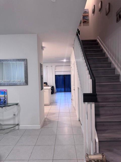 A tiled hallway leads past a staircase to a living area with sliding glass doors — 14852 SW 183rd Ter, Miami FL 33187, MIAMI, FL