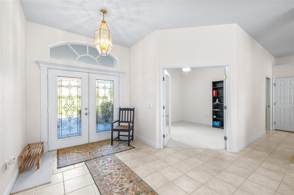 A bright foyer features tile flooring, a double-door entry, a pendant light, and an office — 2692 HUNTINGTON HILLS DR, LAKELAND, FL