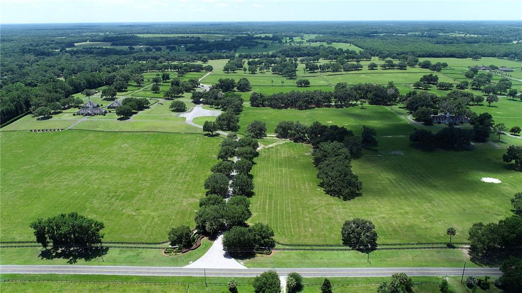 An aerial view shows a large, fenced rural property with green pastures and scattered trees — 6800 & 6500 NW 193RD STREET, MICANOPY, FL