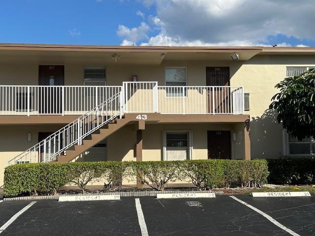 A two-story apartment building exterior features a white metal staircase and balcony railing — 600 NW 77th Avenue # 208, Margate FL 33063, MARGATE, FL