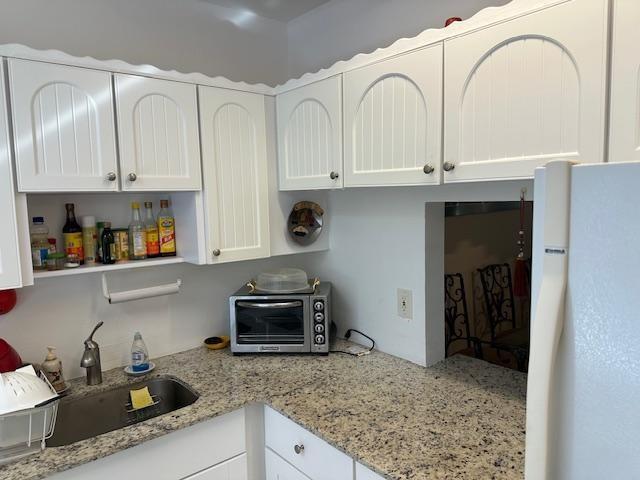 A kitchen features white arched cabinets, granite countertops, a stainless steel sink, and a toaster oven — 600 NW 77th Avenue # 208, Margate FL 33063, MARGATE, FL