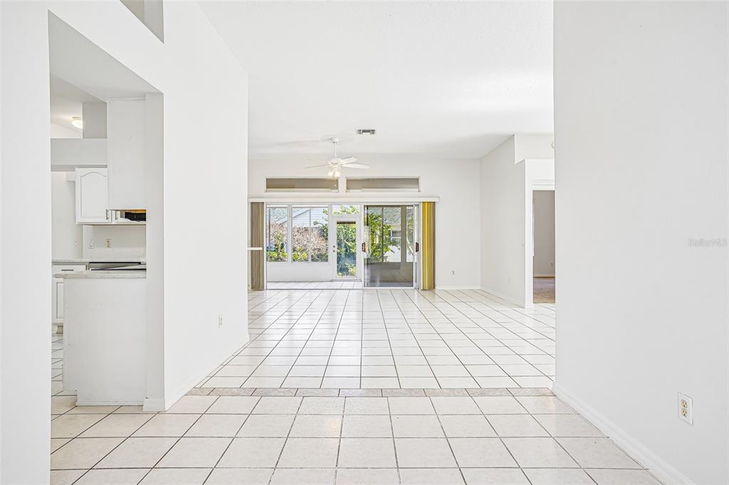 A bright, tiled living area leads to a sunroom through large sliding glass doors — 2013 SANTO DOMINGO DRIVE, THE VILLAGES, FL