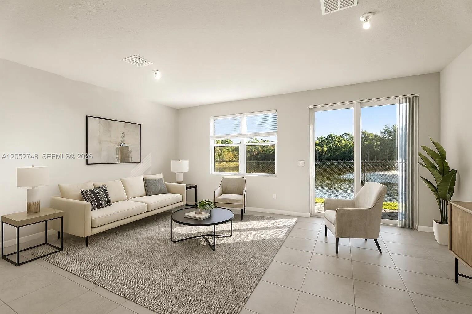 A living room features a sofa, two armchairs, a coffee table, and a lake view — 3939 SE Mentmore Ln # 3939, Stuart FL 34997, STUART, FL
