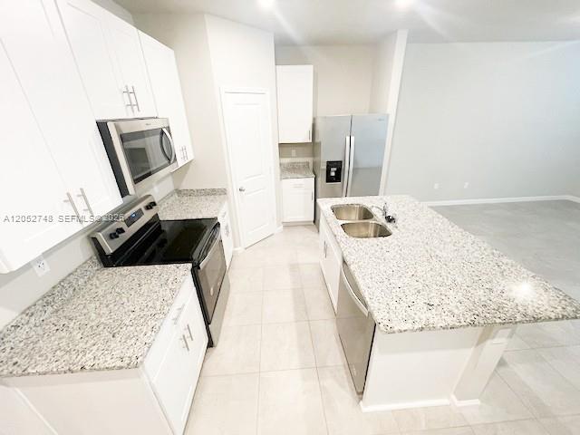 A modern kitchen features white cabinets, granite countertops, stainless steel appliances, and a central island — 3939 SE Mentmore Ln # 3939, Stuart FL 34997, STUART, FL