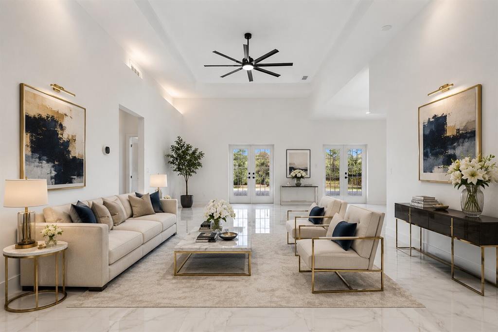 A bright, modern living room features white walls, marble floors, gold-accented furniture, and a ceiling fan — 17545 GLENDA DRIVE, SPRING HILL, FL
