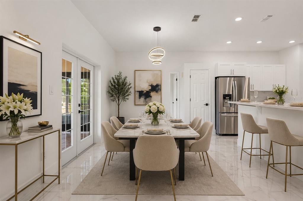 A dining area with a marble table, upholstered chairs, and a modern light fixture — 17545 GLENDA DRIVE, SPRING HILL, FL