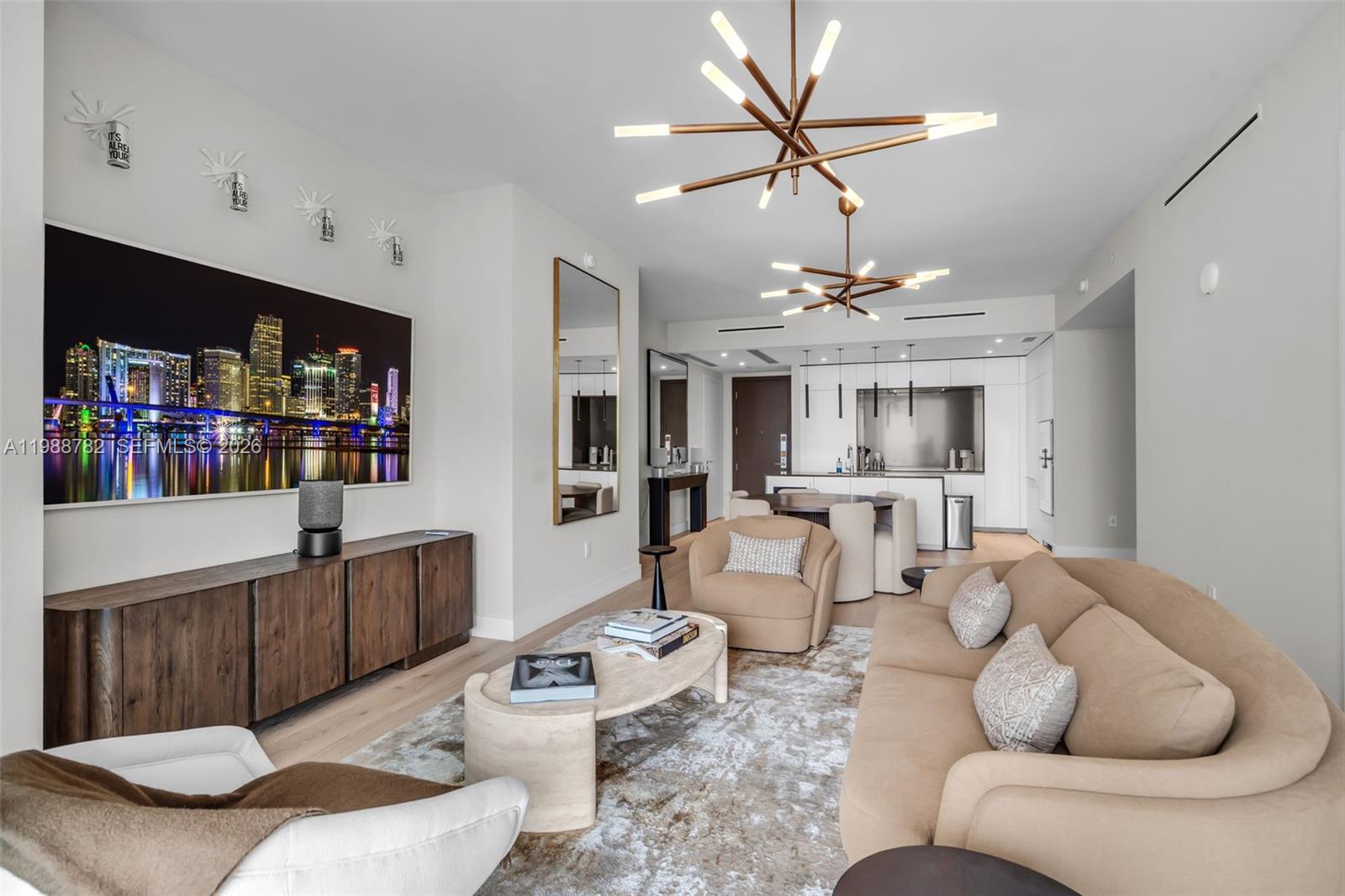 A modern living room features a large television, neutral furniture, and two contemporary light fixtures — 300 Biscayne Boulevard Way # 2605W, Miami FL 33131, MIAMI, FL