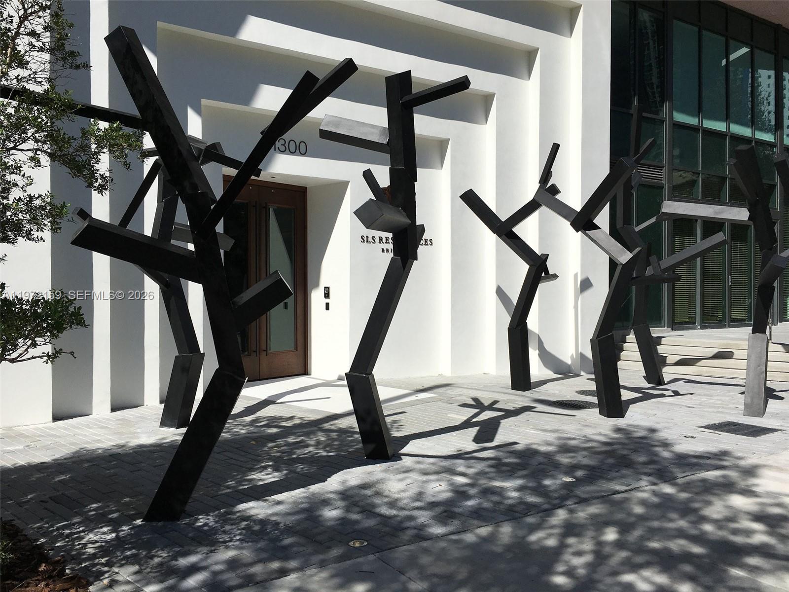 Abstract black metal sculptures stand on a paved walkway in front of a building entrance — 1300 S Miami Ave # 2006, Miami FL 33130, MIAMI, FL