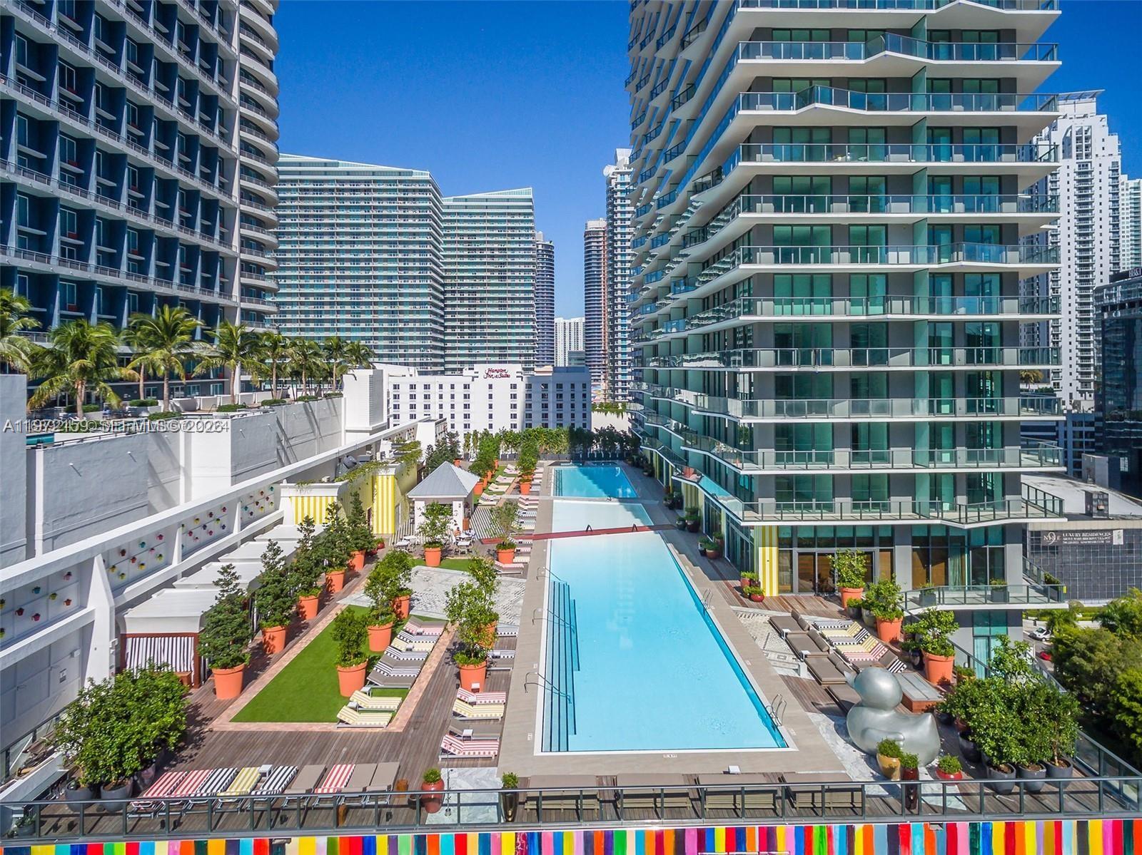 An outdoor swimming pool deck is situated between two modern high-rise apartment buildings — 1300 S Miami Ave # 2006, Miami FL 33130, MIAMI, FL