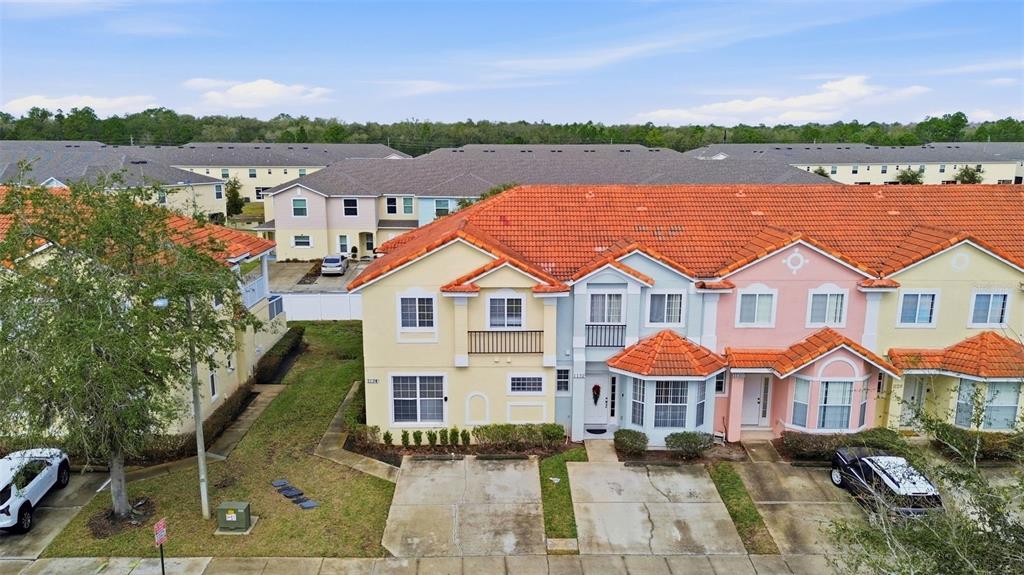An aerial view of a multi-story townhouse complex with orange tile roofs and driveways — 1134 S BEACH CIRCLE, KISSIMMEE, FL
