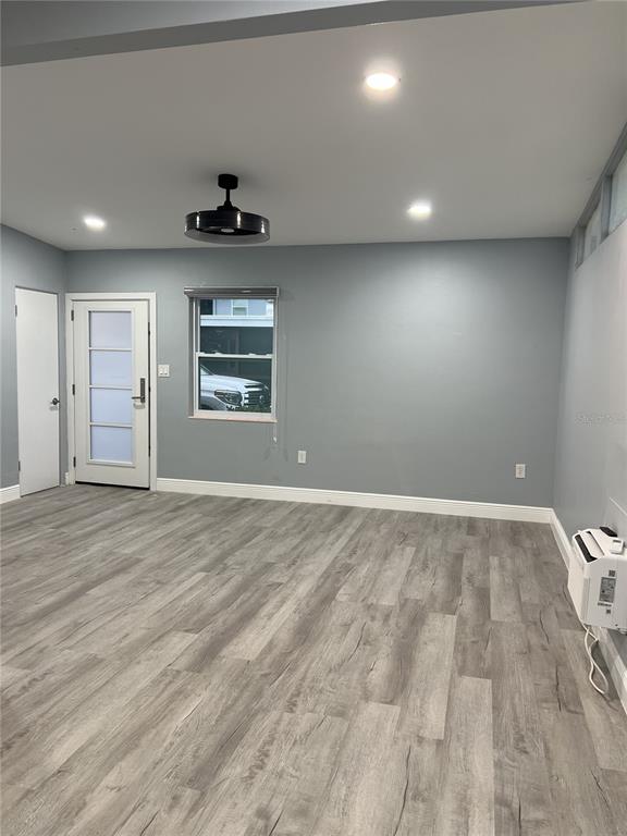 A room with gray walls, light wood-look flooring, a ceiling fan, and a glass-paneled door — 1746 8TH STREET, SARASOTA, FL