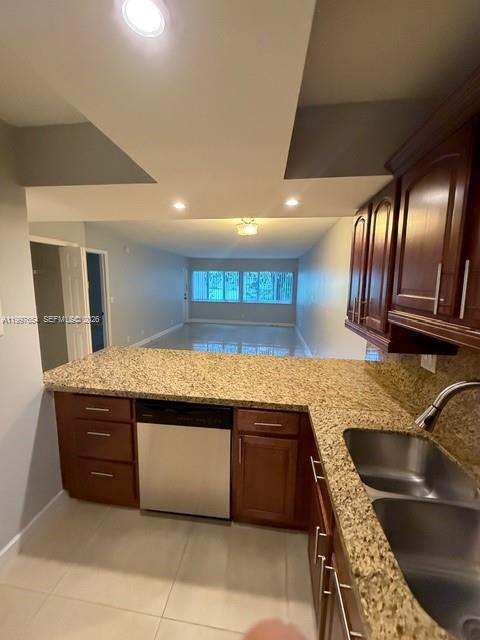 A kitchen with wood cabinets and granite countertops overlooks an open living area — 100 Lakeview Dr # 115, Weston FL 33326, WESTON, FL