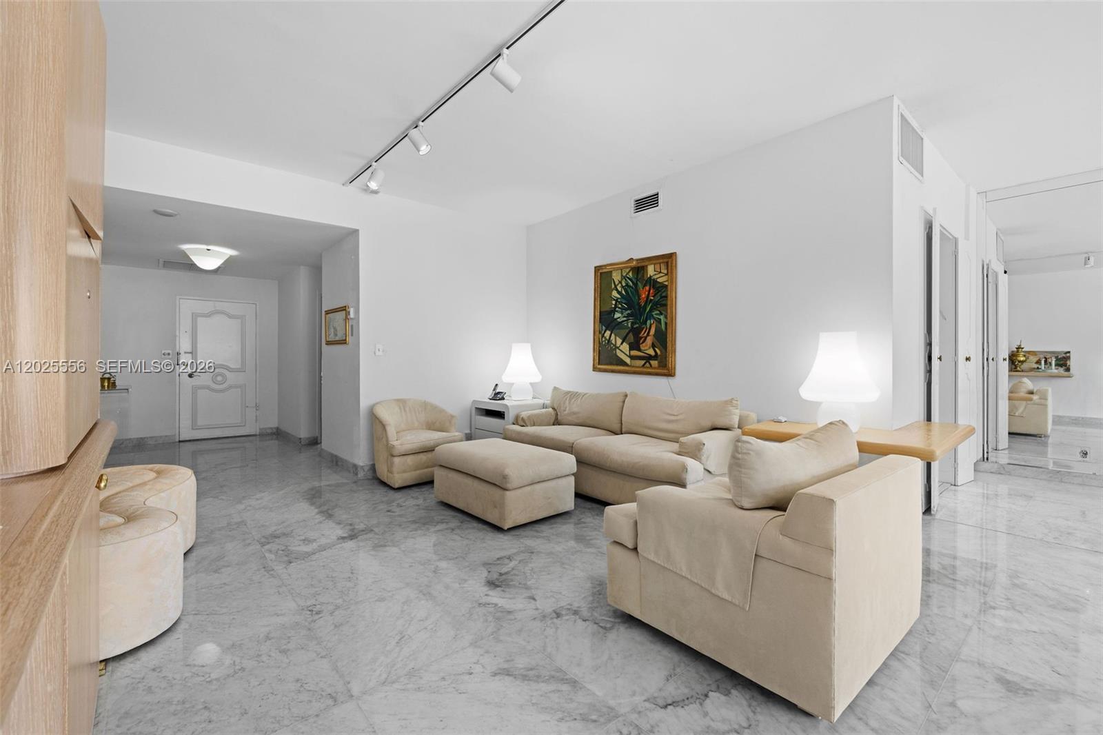 A living room features light-colored furniture, marble flooring, and track lighting on a white ceiling — 4925 Collins Ave # 1A, Miami Beach FL 33140, MIAMI BEACH, FL