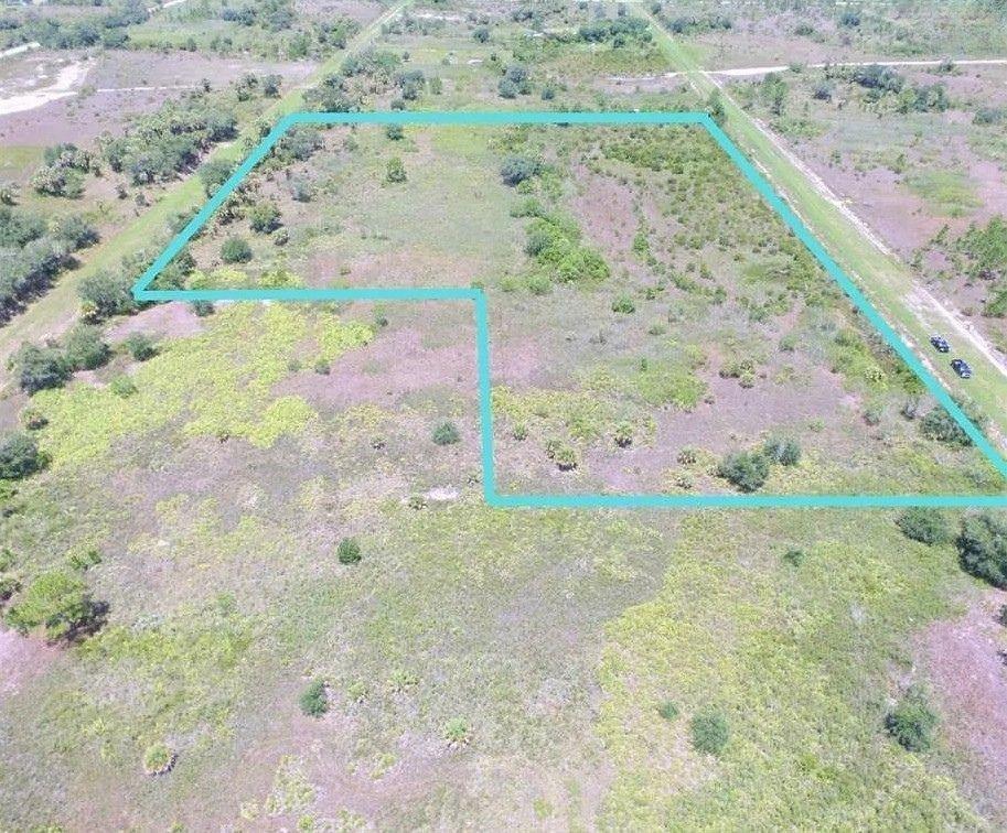 An aerial view shows a vacant, grassy plot of land outlined in bright blue — 17065 NW 306th Street, Okeechobee FL 34972, OKEECHOBEE, FL