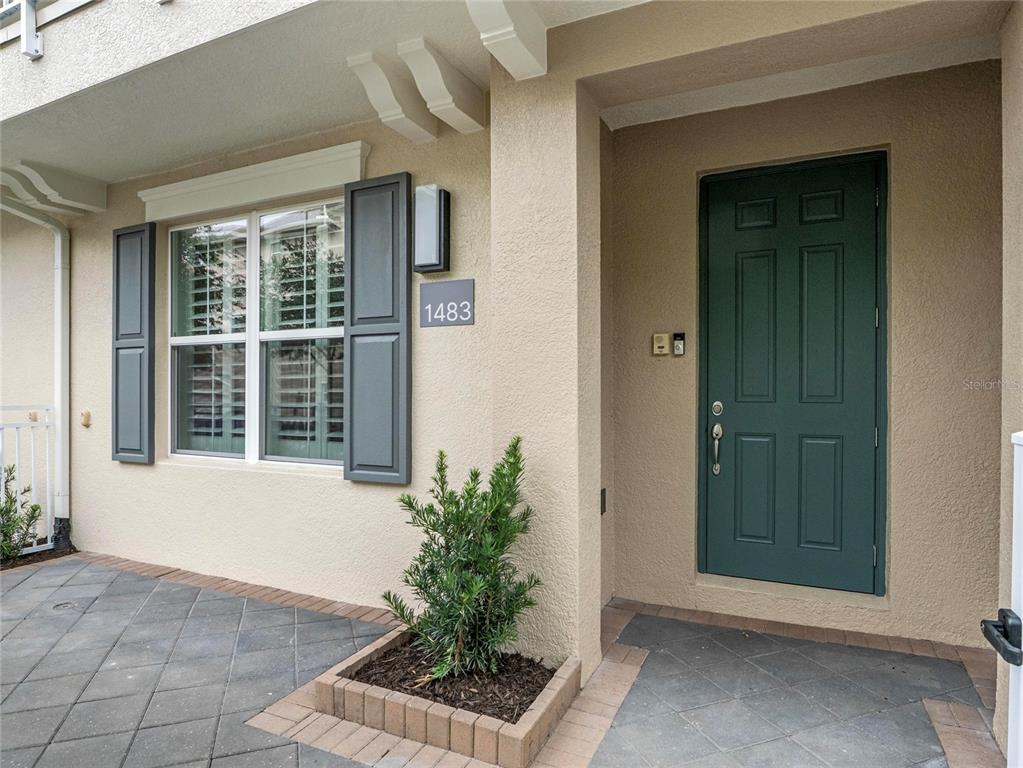 The exterior of a home features a dark green front door and a small planter — 1483 LAKE GEORGE DRIVE, LAKE MARY, FL