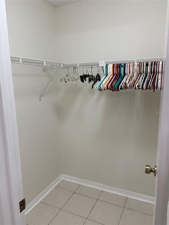 A walk-in closet features white walls, tile flooring, and a white wire shelving unit — 2449 GRAND TETON CIRCLE UNIT 2449, WINTER PARK, FL