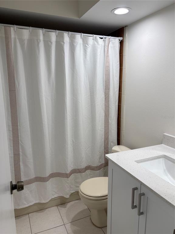 A bathroom features a white vanity with a stone countertop, a toilet, and a shower curtain — 2449 GRAND TETON CIRCLE UNIT 2449, WINTER PARK, FL