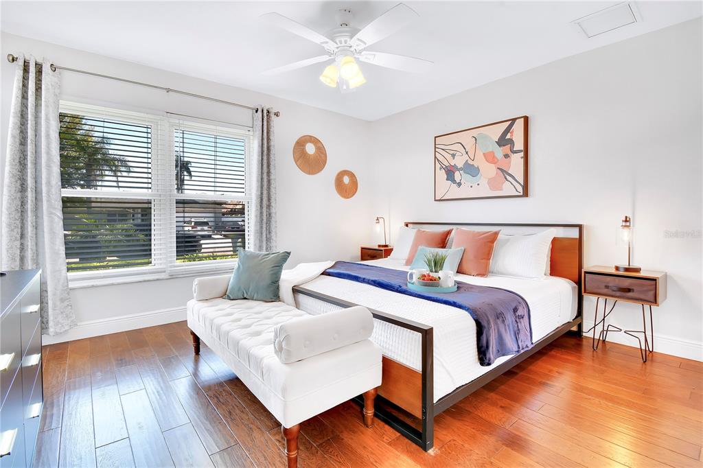 A bedroom features a bed with a blue runner, a white bench, and wood flooring — 5730 IMPERIAL KEY, TAMPA, FL