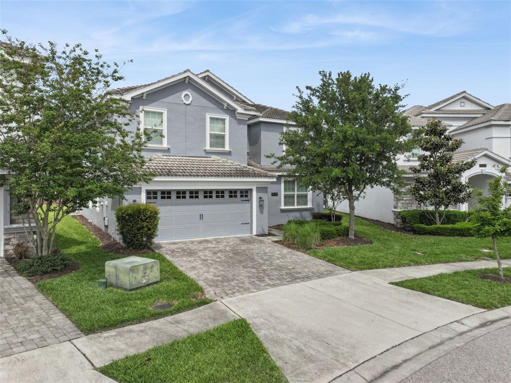 A two-story gray house with a two-car garage and a paved driveway — 9038 STINGER DRIVE, DAVENPORT, FL