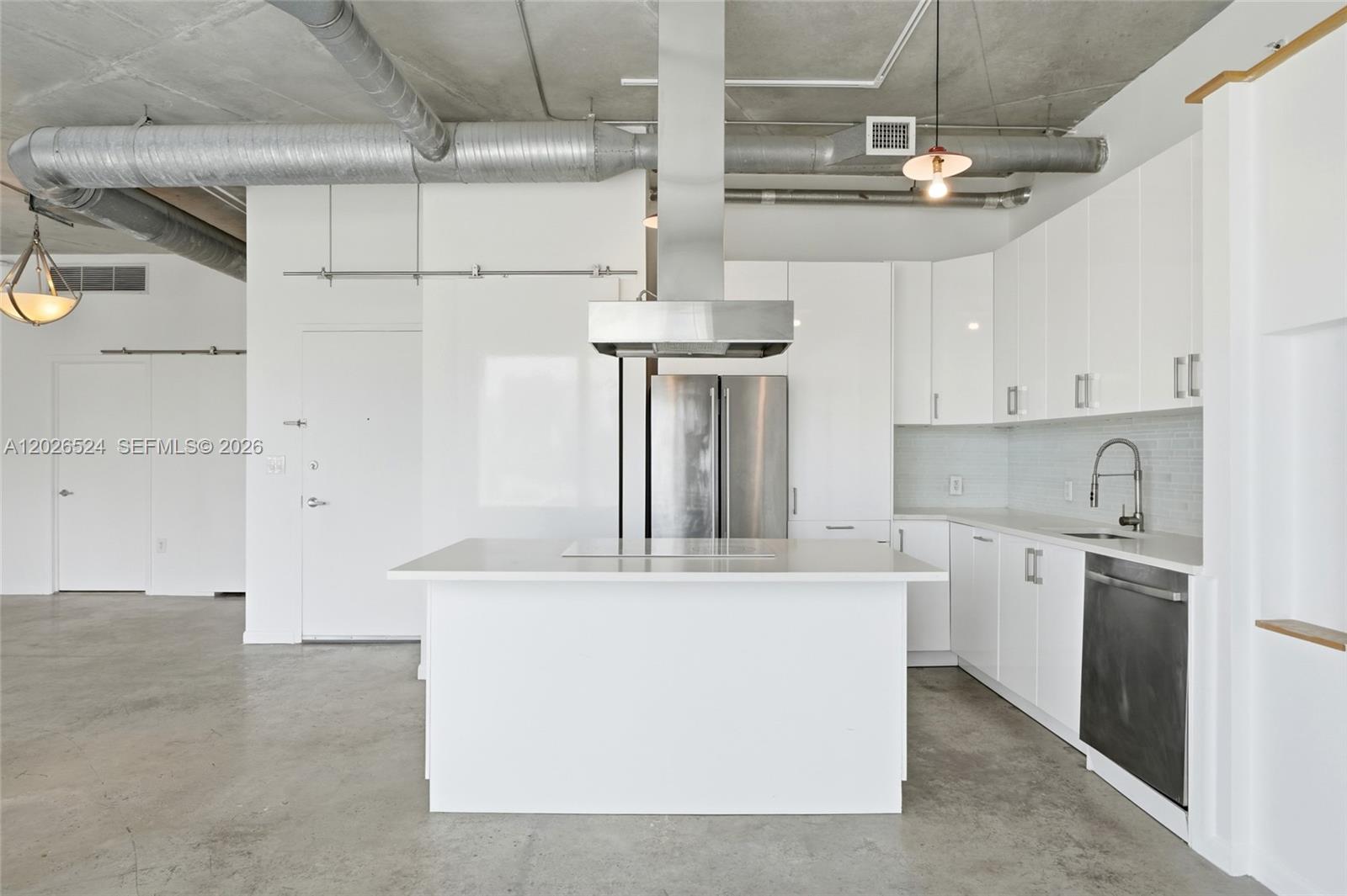 A modern kitchen features white cabinets, stainless steel appliances, and an exposed concrete ceiling — 10 SW South River Dr # 804, Miami FL 33130, MIAMI, FL